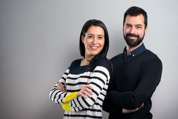 Couple with their arms crossed on grey background