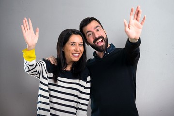 Couple saluting on grey background