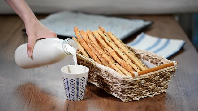Freshly baked, rustic Italian grissini bread sticks with milk