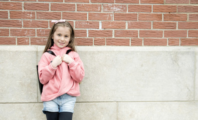 Portrait of cute girl with backpack outside of school