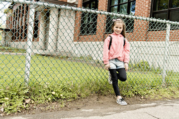 Portrait of cute girl with backpack outside of school