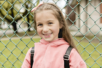 Portrait of cute girl with backpack outside of school