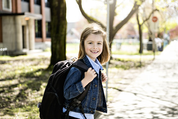 Portrait of cute girl with backpack outside of school