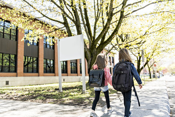Two students outside at school standing together