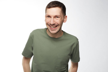 People, positive emotions and facial expressions concept. Headshot of satisfied confident handsome man grins at camera, glad to find suitable well paid job, isolated over white studio wall.