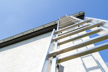 three section aluminum ladder leaning against house