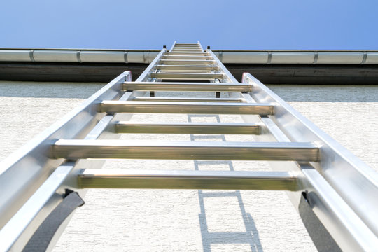 three section aluminum ladder leaning against house