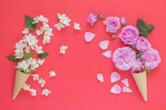 Two waffle cone with flowers bouquets on blue surface