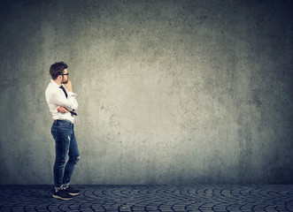 Pensive man looking at empty wall