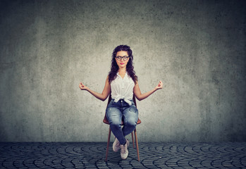 Meditating woman on chair with eyes closed