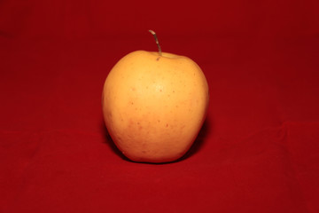yellow apple on a red background