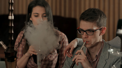 Group of young people smoking hookah in the lounge caffee
