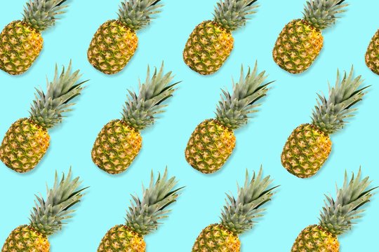 Colorful fruit pattern, Pineapples on a pastel blue background. Top view.