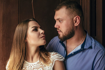 guy and girl look at each other, portrait of a romantic couple,man and woman kissing in a dramatic light, girl holding flowers in hands, young beautiful bride in white dress holding wedding bouquet