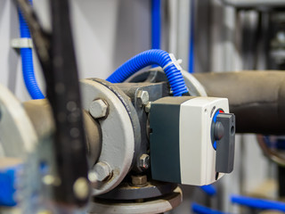 Electrical three-way mixing valve on a pipes in boiler room. Selective focus