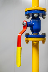 Blue gas valve on yellow pipe