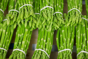 fresh green asparagus in bundles decorated at the weekly market, can be used as background  - obrazy, fototapety, plakaty