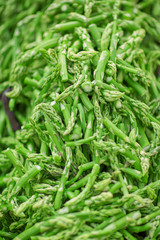 fresh green asparagus tips decorated at the weekly market, can be used as background - obrazy, fototapety, plakaty