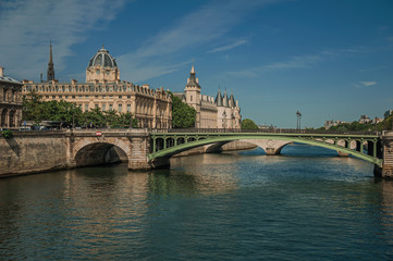 Obraz na płótnie Canvas Bridge over the Seine River and the Conciergerie building with sunny blue sky at Paris. Known as the “City of Light”, is one of the most impressive world’s cultural center. Northern France.