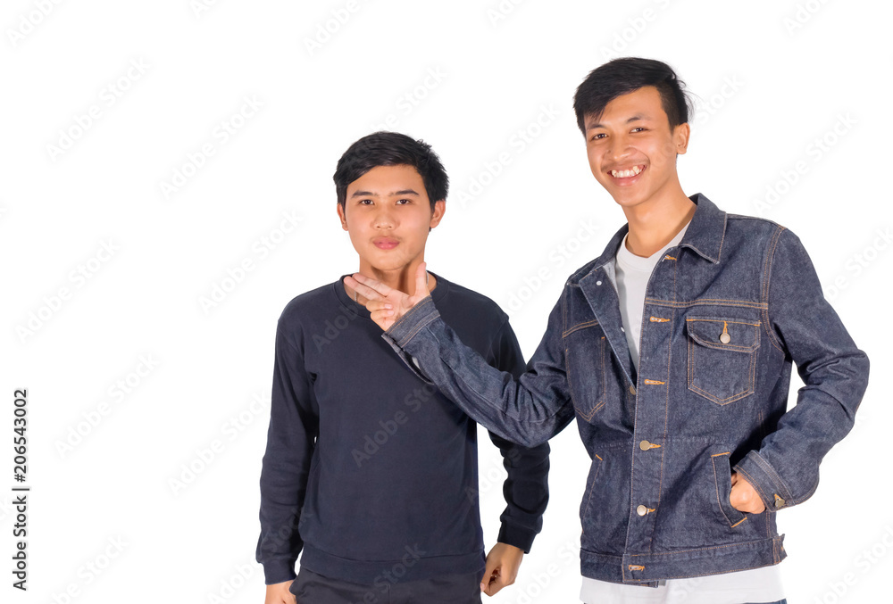 Wall mural A young man in jeans jacket  is putting his hands at his friend's chin.