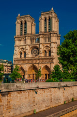 Fototapeta na wymiar People, tree-lined Seine River and gothic Notre-Dame Cathedral at Paris. Known as the “City of Light”, is one of the most impressive world’s cultural center. Northern France. Retouched photo