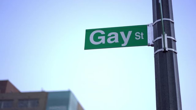 Gay street sign in downtown city evening hours 4k
