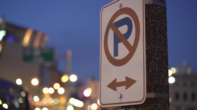 No parking sign along street sign evening hours of city 4k
