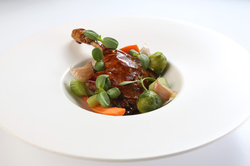 duck leg with vegetable garnish