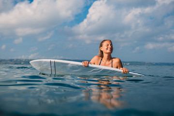 Happy surf woman with surfboard. Professional surfer with surfboard in ocean