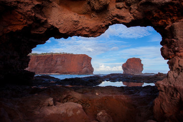 Rocky Red Coastline of Lanai, Hawaii framed by a natural rock arch