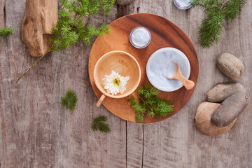 Preparing handmade hydrating natural gel and anti-aging cosmetic from extract of aloe vera leaves with pebbles and wooden background for zen beauty, top view