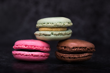 three macaroons on dark background