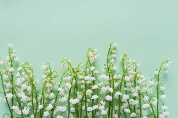 Foto auf Acrylglas Romantischer sanfter Blumenhintergrund, Maiglöckchen auf mintfarbenem Hintergrund, Draufsicht, flaches Layout. © Tatiana Morozova