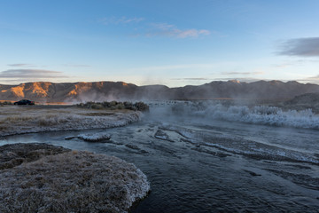 Sunrise over a misty hot creek in the winter