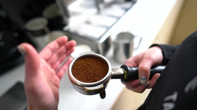 Barista holding portafilter with ground coffee