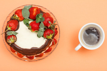 Homemade chocolate cake decorated with fresh strawberries on glass plate