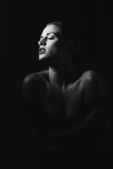 Young brunette woman in black lingerie in chiaroscuro lighting