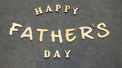 Fototapeta premium Happy father's day word combinations made of wooden letters on a black table. Father's day greetings.