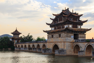Fototapeta na wymiar Traditional, ancient Chinese bridge across river at sunset