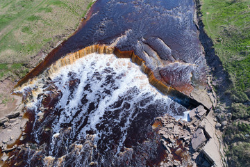 Tosnensky (Gertovsky) waterfall close up in the sunny May afternoon. Leningrad Region, Russia...