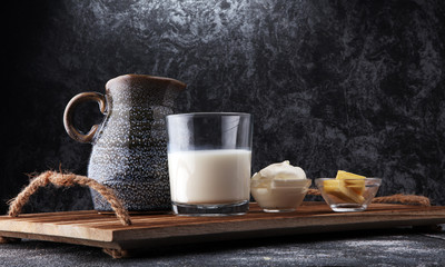 milk products - tasty healthy dairy products on a table sour cream in a bowl, cream and milk jar