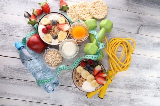 muesli with dairy and fruit, healthy lifestyle. bowl of cereal, fruit and dumbbell