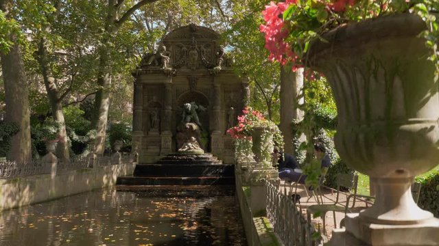 PARIS, FRANCE - SEPTEMBER 29, 2017: In Luxembourg Gardens. Scene with ancient Medici Fountain and people relaxing near water. Jardin du Luxembourg was created in 1612 and covers 23 hectares