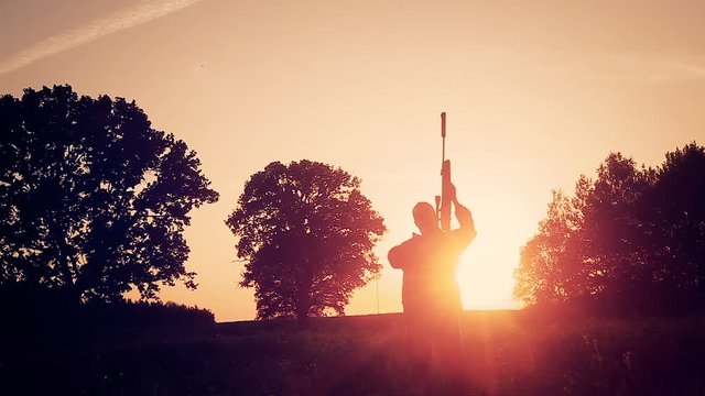 The hunter rejoices in the good fortune. Hands with a gun raised up