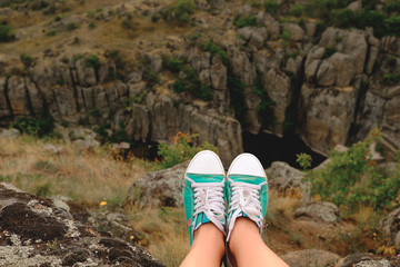 Photo female legs in gumshoes on the background of canyon