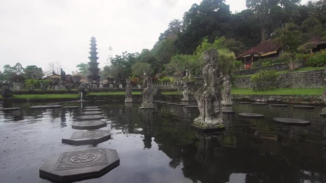 Hindu Balinese Water Palace Tirta Gangga with statues of the gods, fountains on Bali island, Indonesia. Tirta Gangga the former royal water palace is a maze of pools and fountains surrounded by a lush