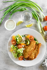 Vegetable salad and breaded chicken breast