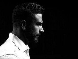 Monochrome portrait of a strong man with a beard. He looks at the camera with different emotions. 