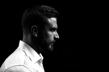 Monochrome portrait of a strong man with a beard. He looks at the camera with different emotions. 