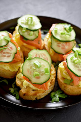 Sandwiches with salmon, scrambled eggs and cucumber
